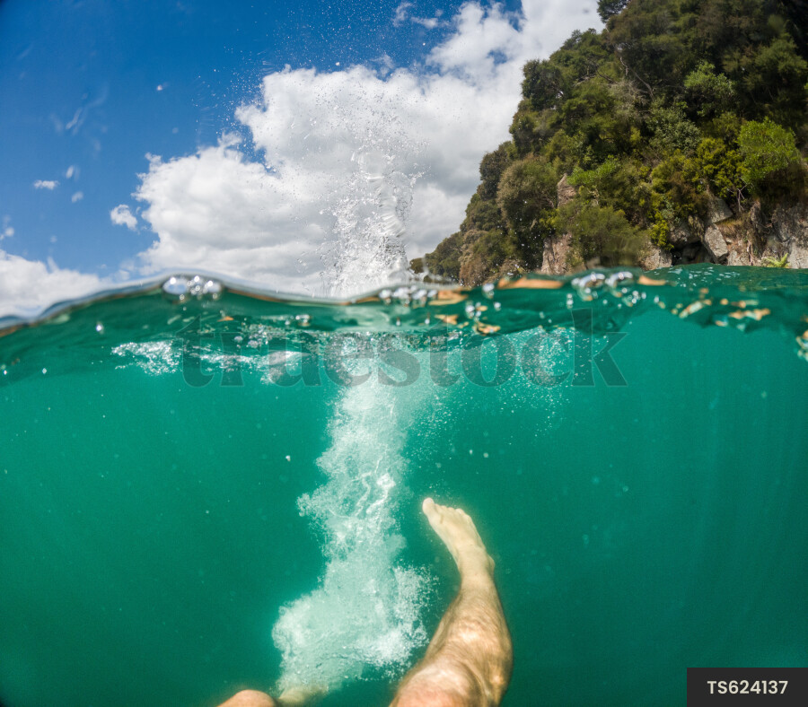Leg of man swimming underwater