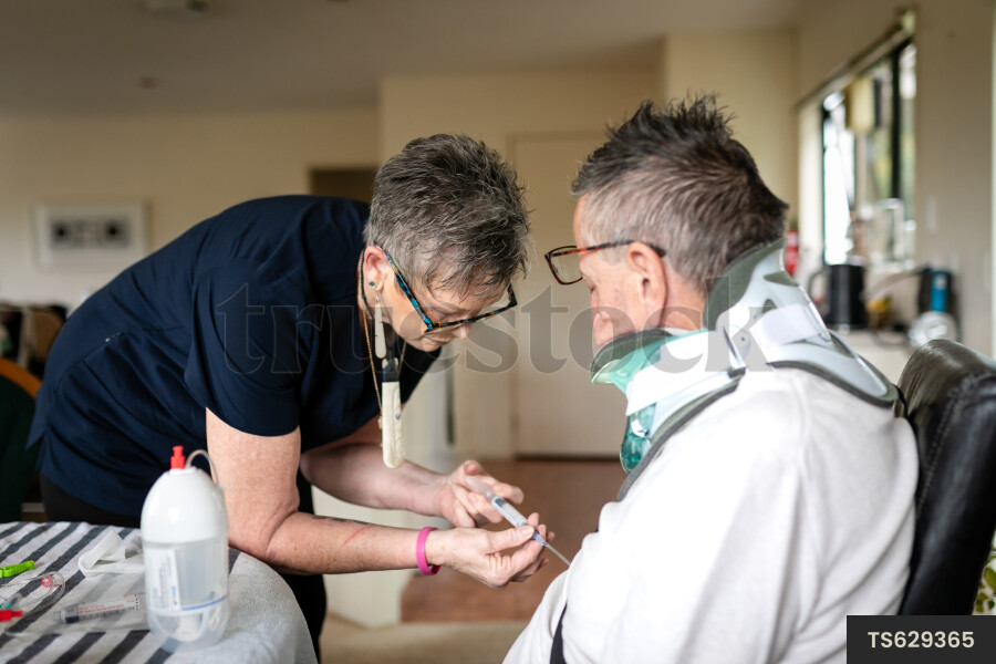 Health carer giving medicine to patient with neck brace
