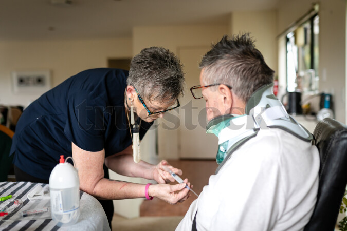Health carer giving medicine to patient with neck brace