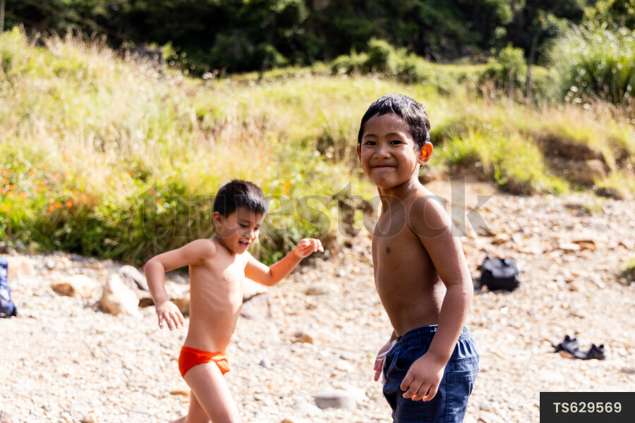 Boys playing on riverbank