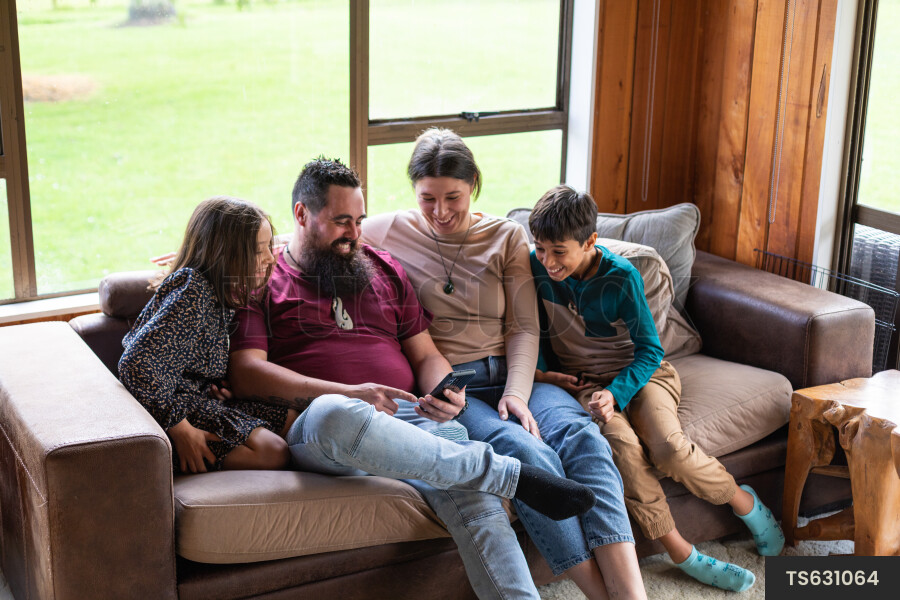 Family Using Phone on Couch
