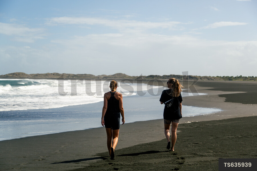 Women walking on Whatipu Beach, Auckland