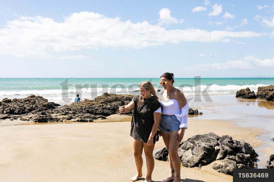 Friends taking selfies on beach