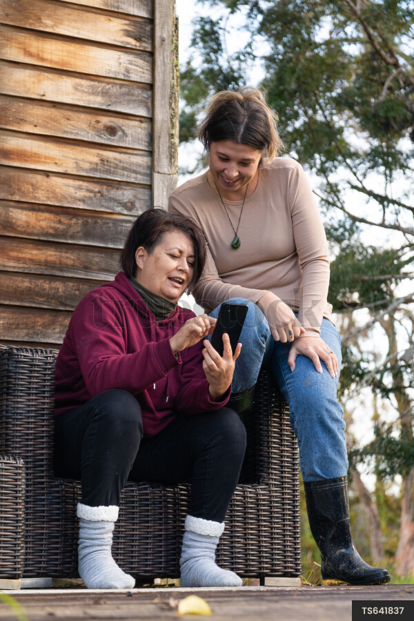Family Using Phone on Deck