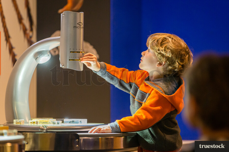 Toddler touching a microscope