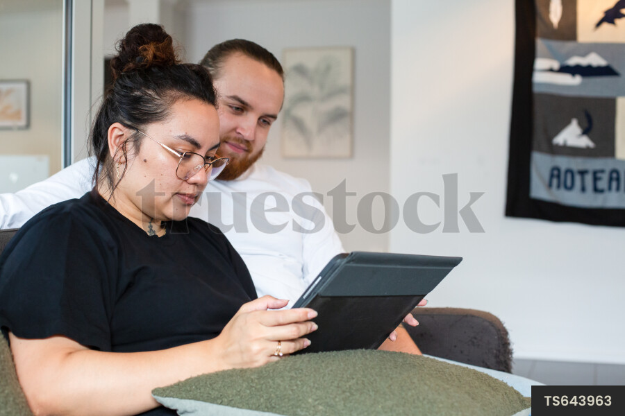 Couple Using iPad on Couch