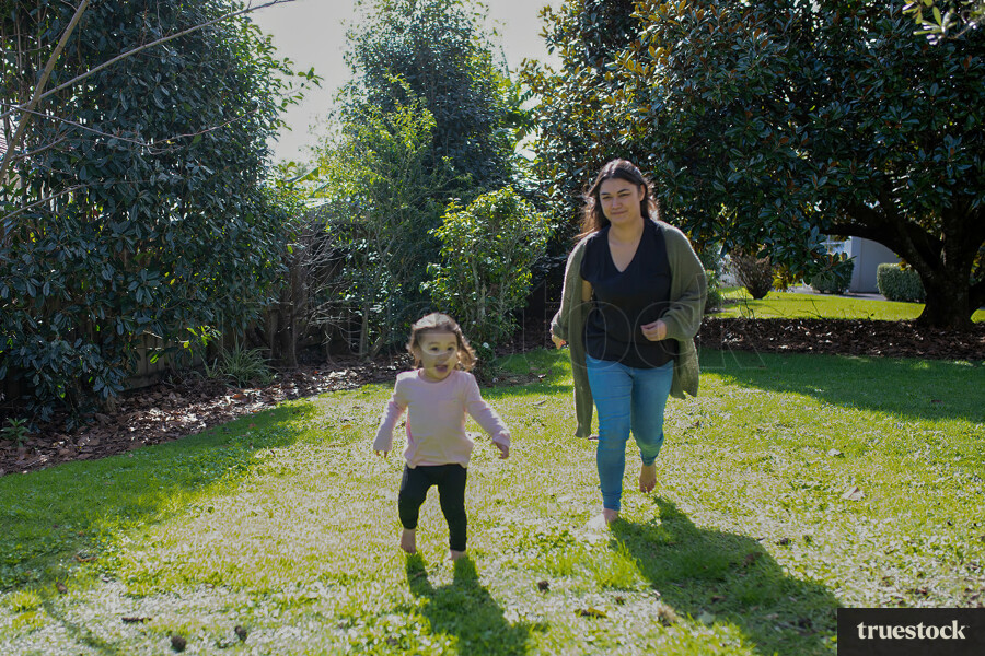 Mother and Daughter Walking in Backyard