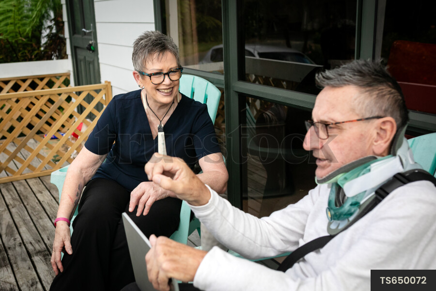 Health carer sitting with patient on deck