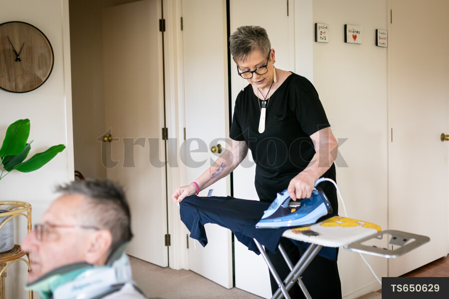 Health carer ironing clothes for patient
