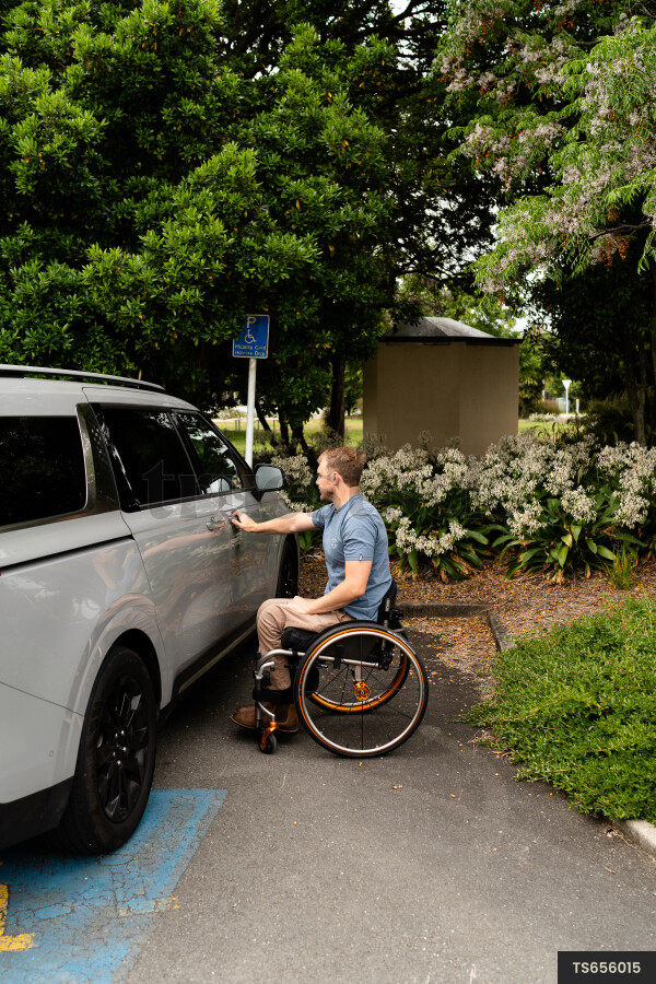 Man with wheelchair by car