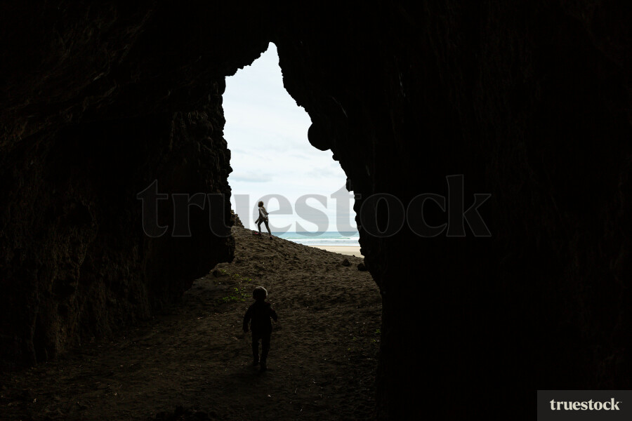 Young Girl Outside of Cave on Beach