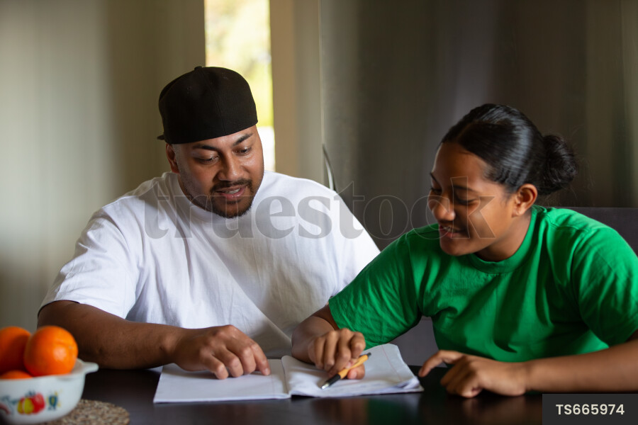 Tongan father doing homework with daughter