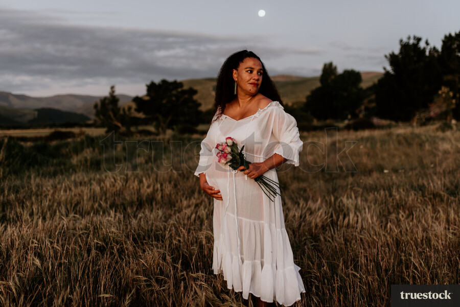 Woman Holding Flowers for Maternity Shoot