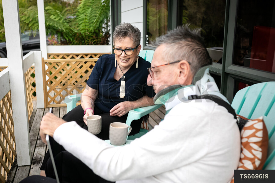 Health carer sitting with patient on deck