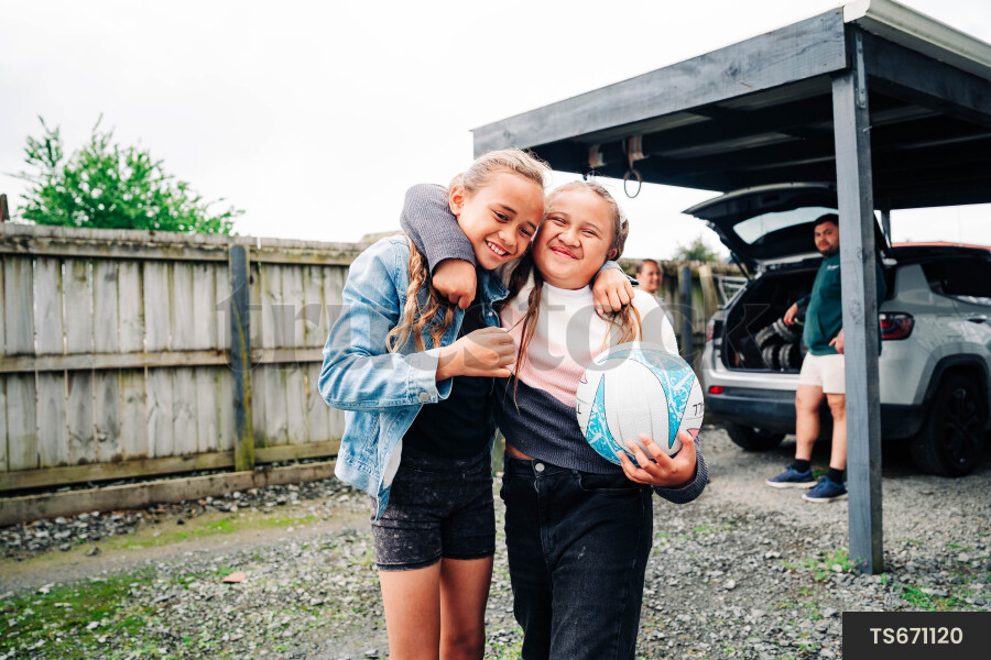 Girls playing by car