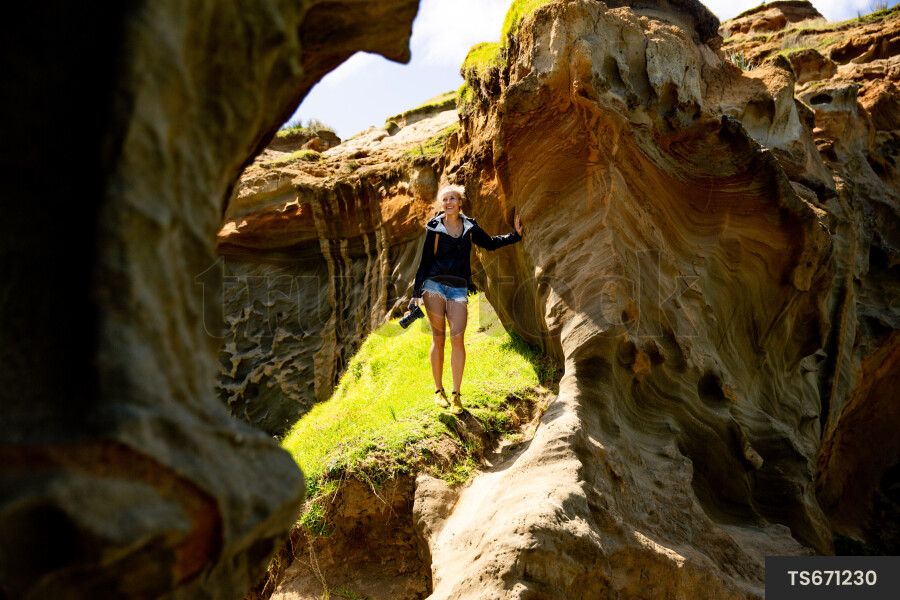 Woman with camera by cliffs