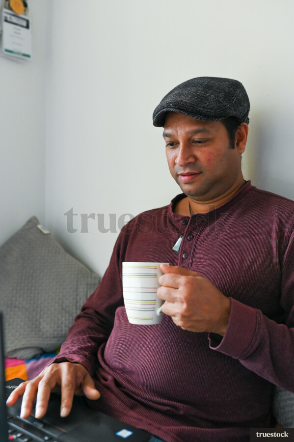 Adult male budgeting finances at home on the bed