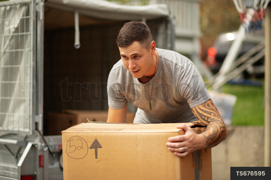 Man packing cardboard boxes while moving out