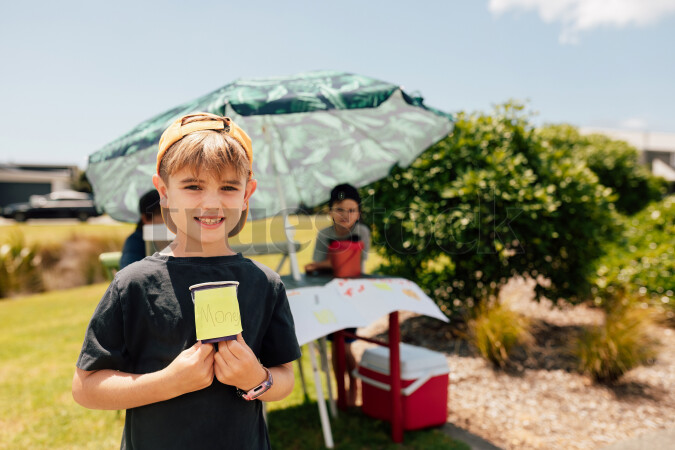 Portrait of Young Boy in Front of Lemonade Stand