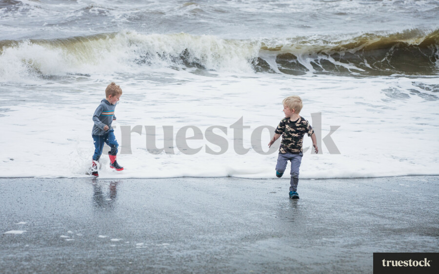 Children running through the water away from the waves