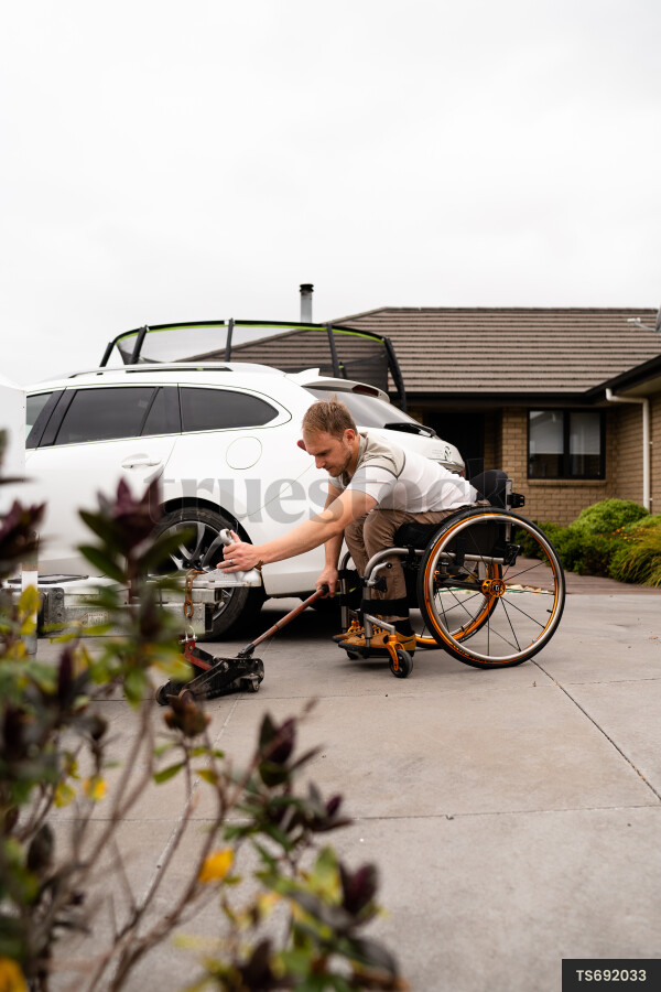 Man in wheelchair using trailer jack