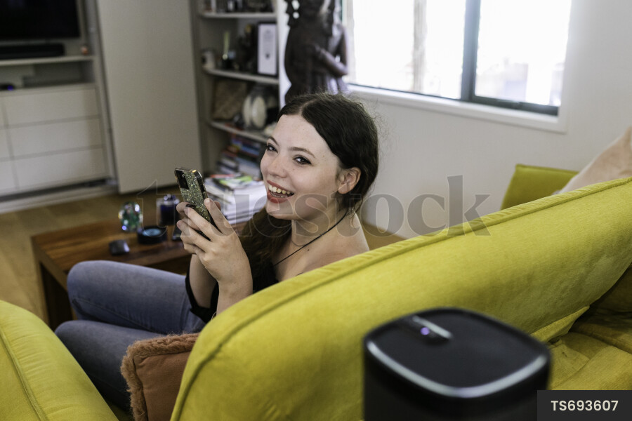 Teenage girl sitting on sofa