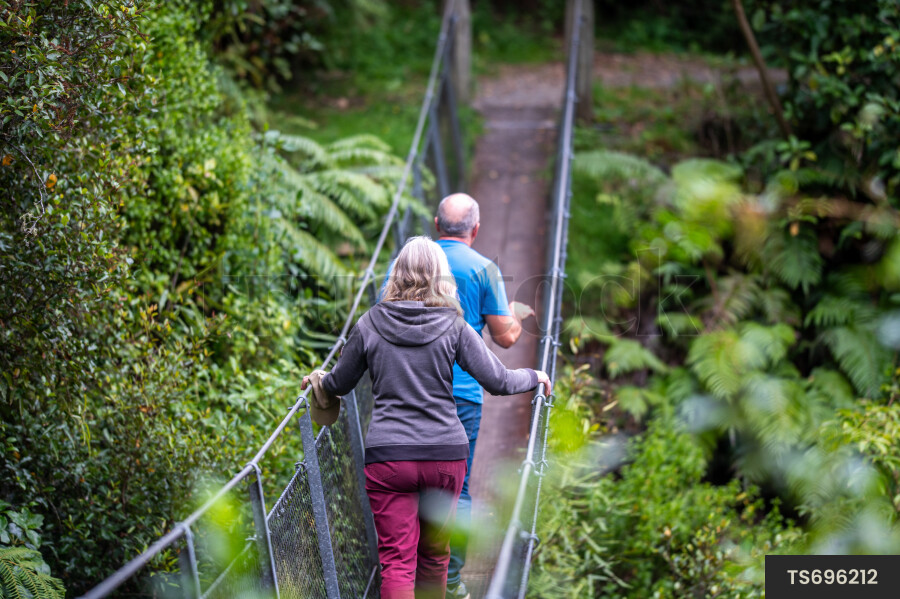 Couple hiking on bridge in forest