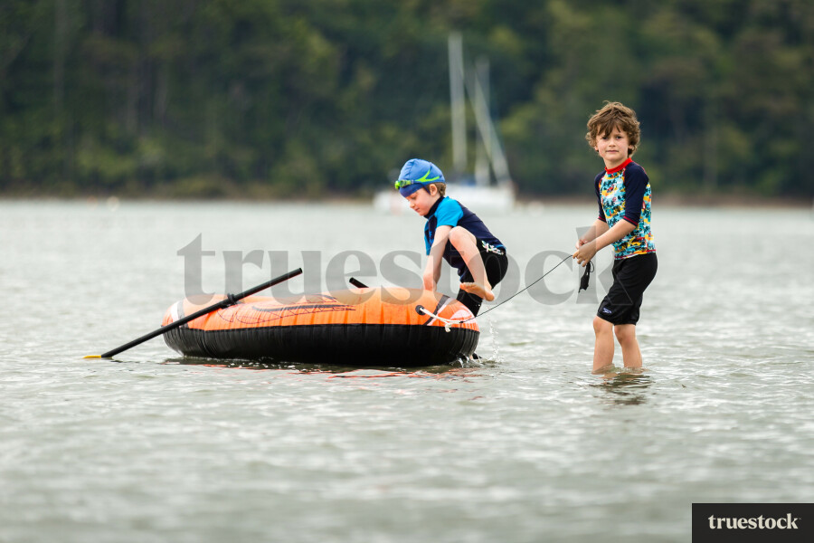Children in the water with inflatable boat