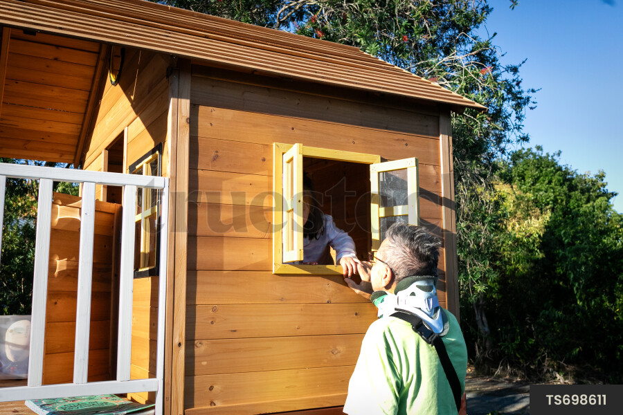 Man playing with granddaughter in playhouse