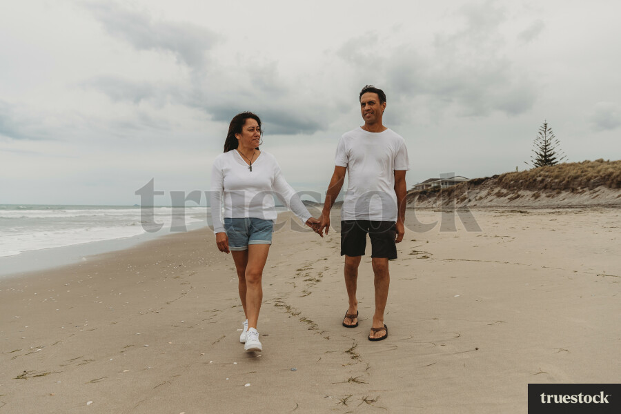 Couple Walking Along The Beach