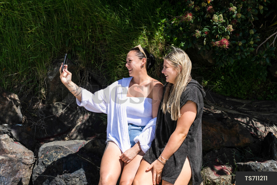 Friends taking selfies on beach