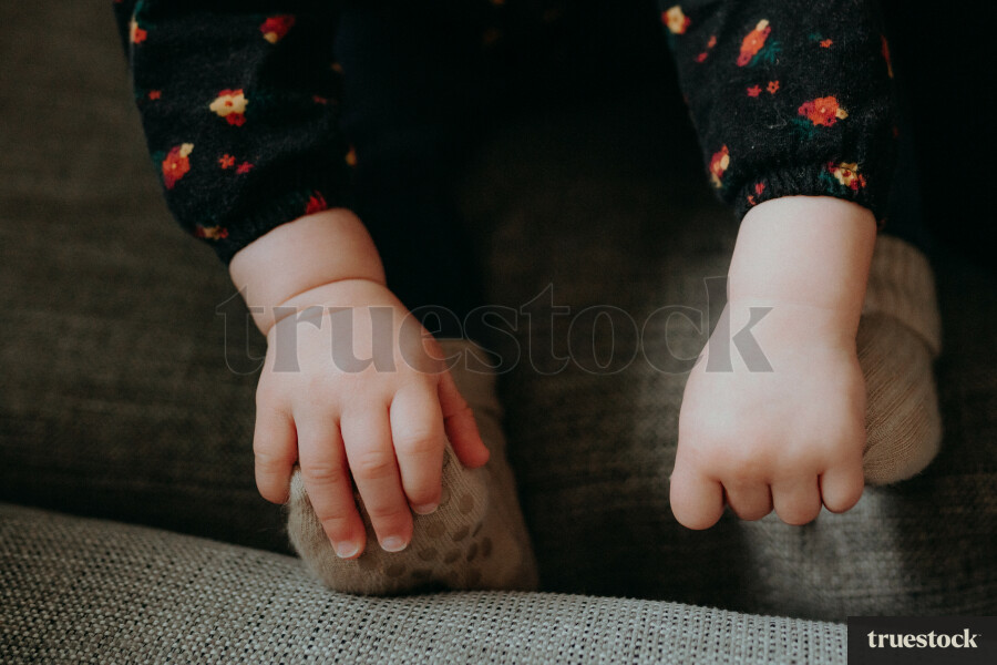 Toddler's hands and feet on the couch
