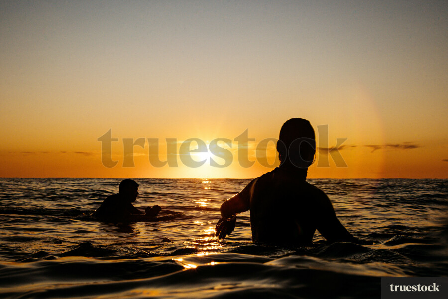 Surfers in Ocean at Sunrise