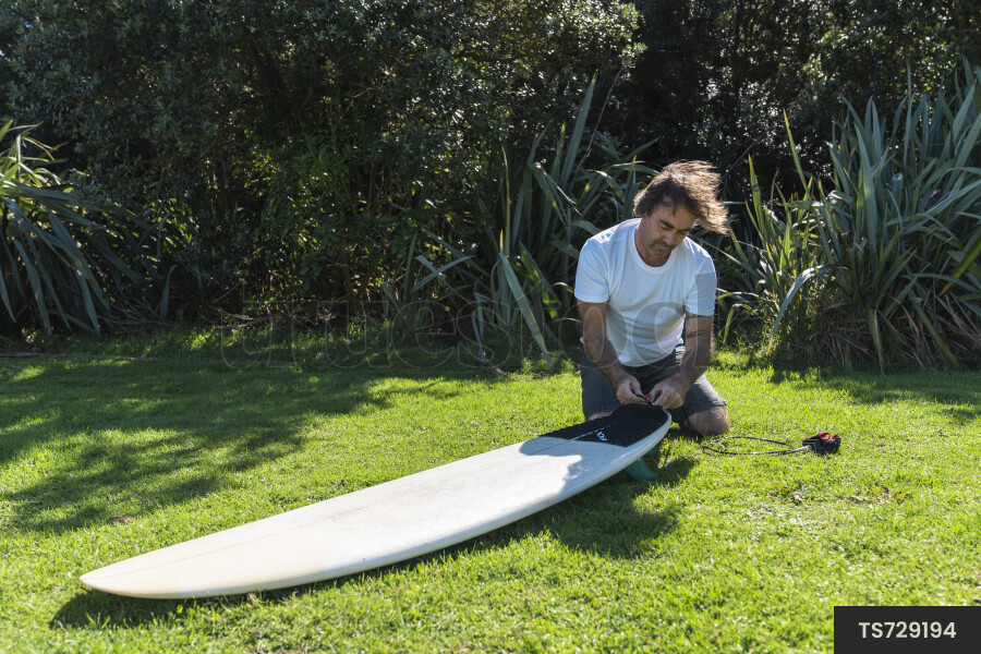 Surfer with surfboard in grass