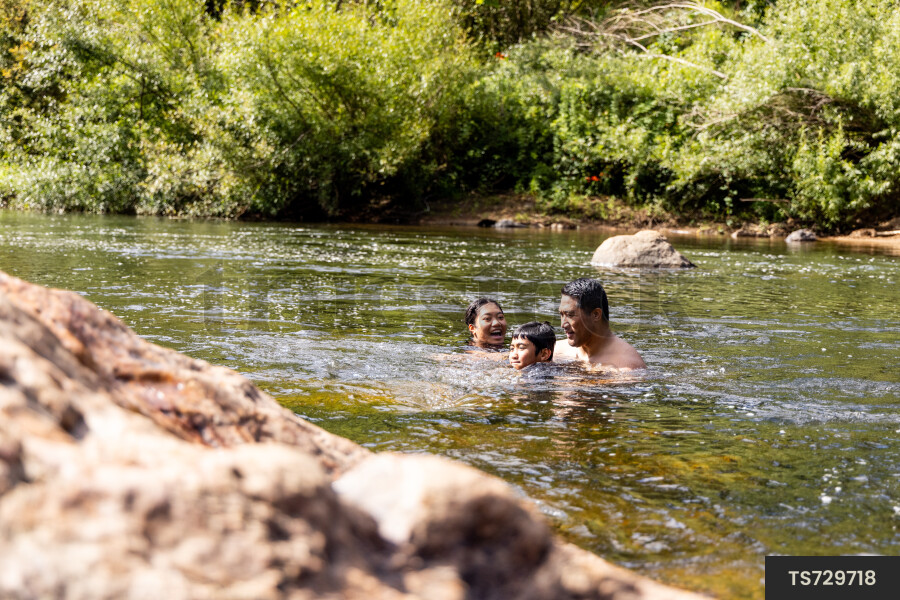 Family swimming in river