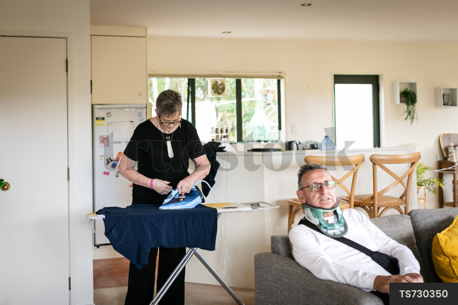 Health carer ironing clothes for patient