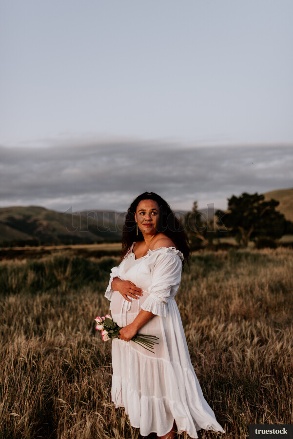 Woman Holding Flowers for Maternity Shoot