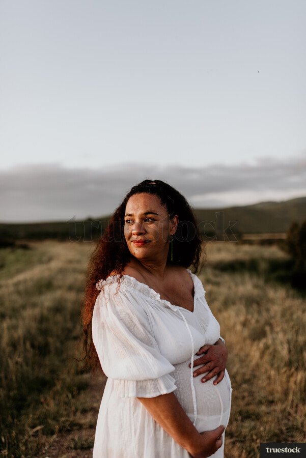 Woman Standing in Field for Maternity Shoot