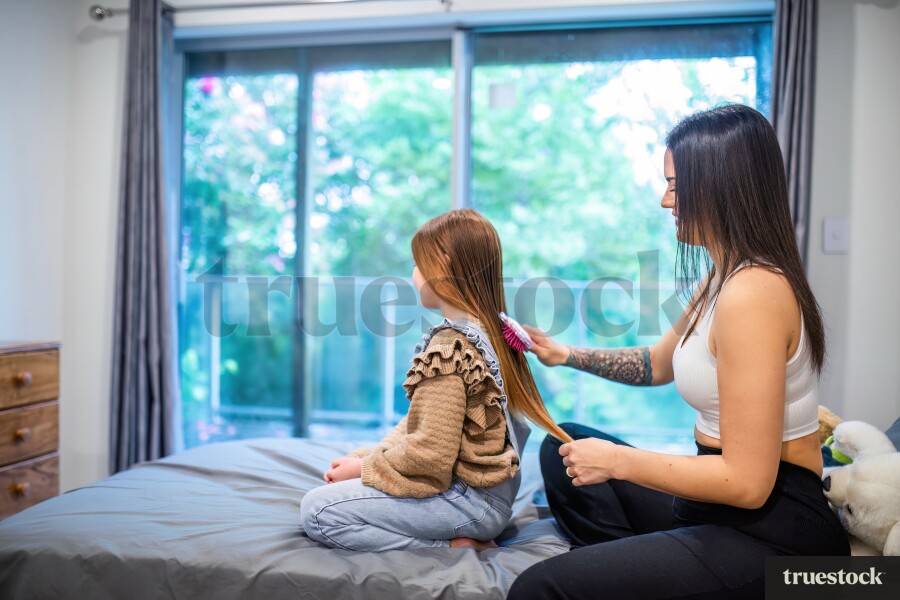 Mother Brushing Daughters Hair
