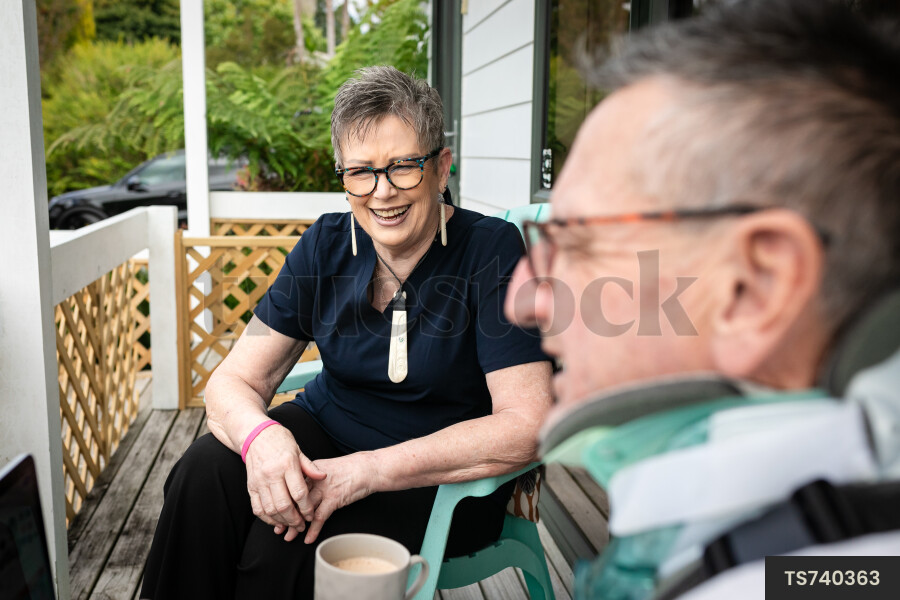 Health carer sitting with patient on deck