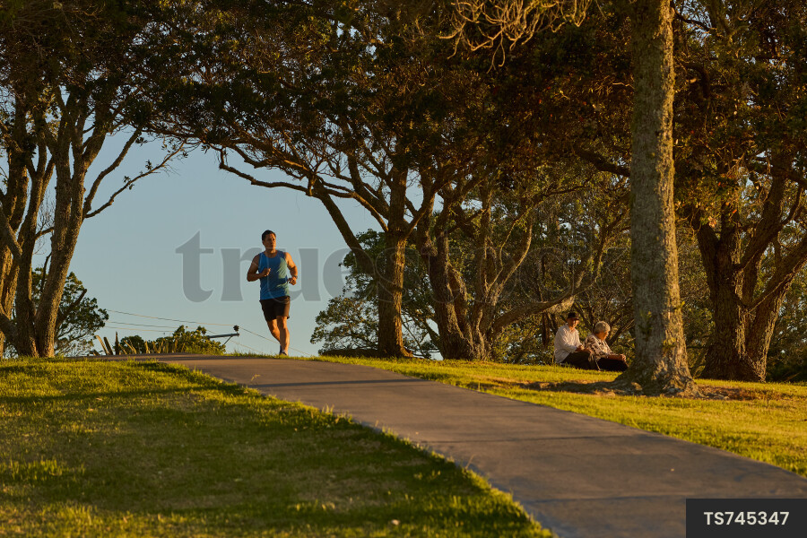 Tongan man running on sidewalk in park