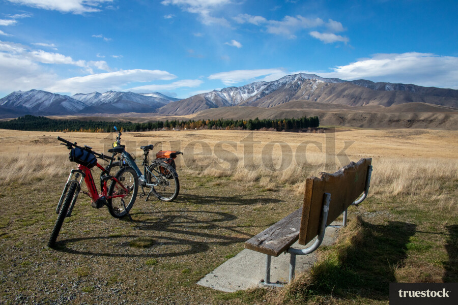 Two Bikes by Bench Seating With Mountain Landscape
