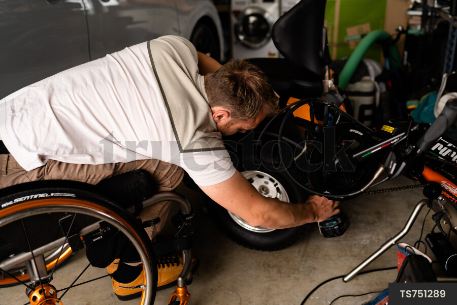 Man in wheelchair doing DIY in garage