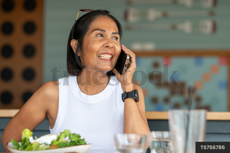 Asian woman on smart phone over lunch in house