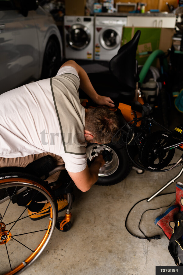 Man in wheelchair doing DIY in garage