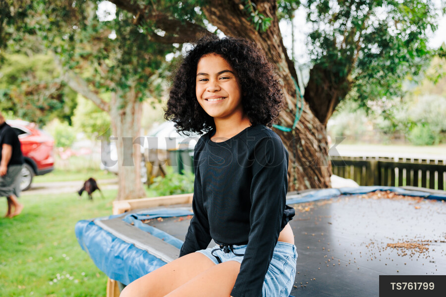 Young Girl Sitting On Trampoline