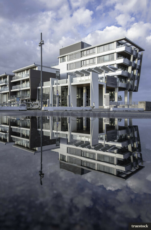 Reflection of apartment building in the water on the concrete