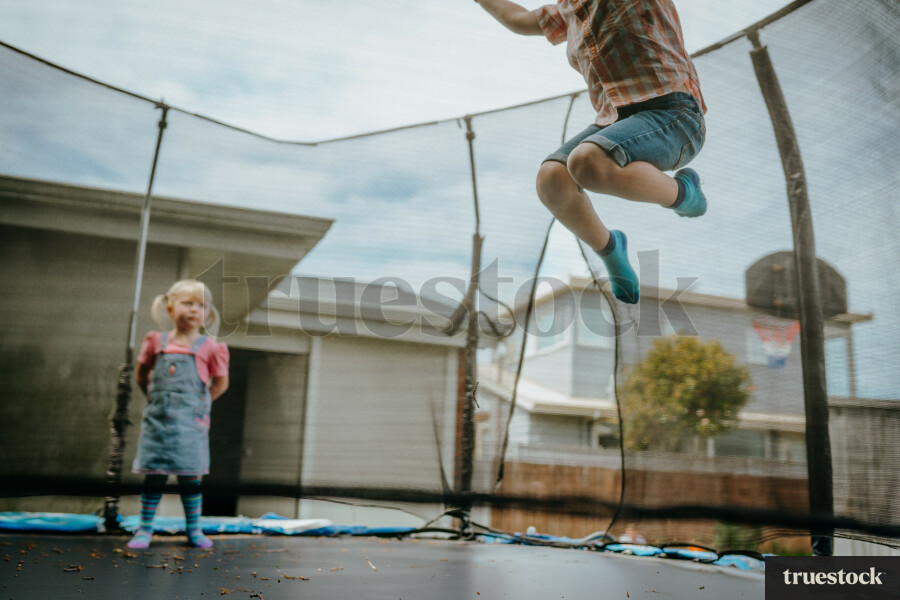 Brother and sister playing on a trampoline