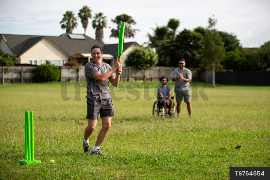 Friends playing cricket at park