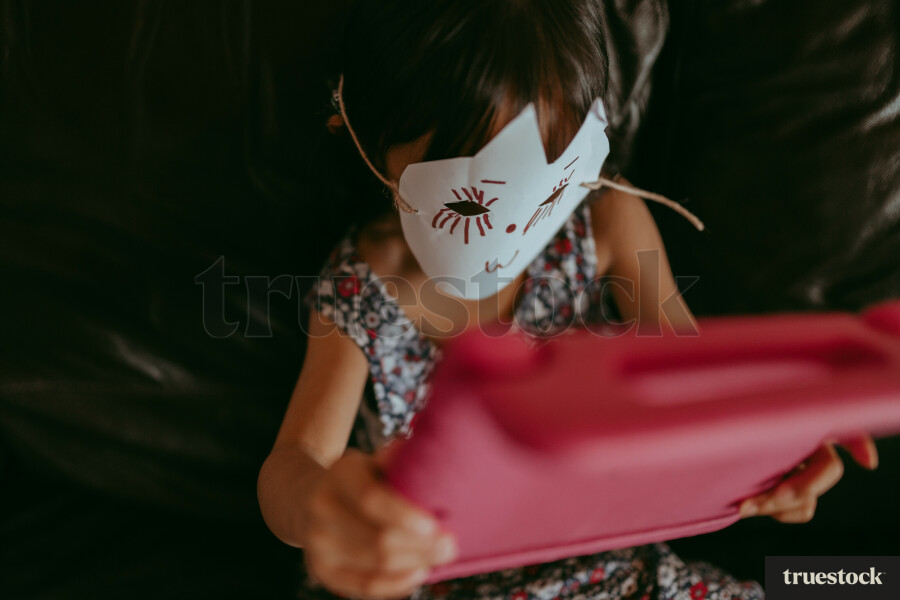 Girl wearing a paper mask on the iPad